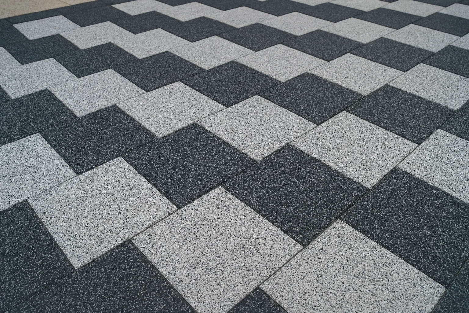 Nowoczesny taras z prostokątnych, dwukolorowych płytek granitowych ułożonych naprzemiennie na mijankę